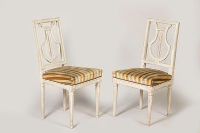 pair of white painted chairs with striped upholstered cushions