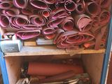 many rolls of fabric sitting on a shelf in a room