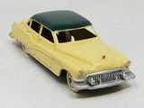 a yellow toy car with a green roof on a white surface