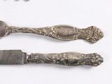 two forks and a knife on a white surface