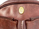 the inside of a brown leather bag with a gold button