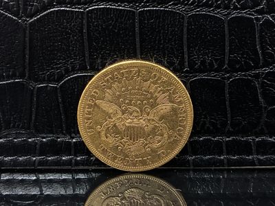 black alligator skin wallet with a gold coin on top of it