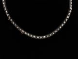 une photo en noir et blanc d'un collier sur fond noir