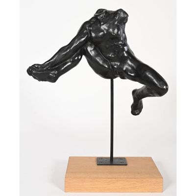 a black sculpture of a man on a wooden base