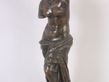 statue en bronze représentant une femme, les mains posées sur la poitrine