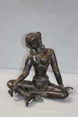 statue d'une femme assise en position du lotus sur une surface blanche