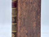 an old book sitting on top of a white surface
