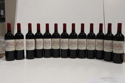 several bottles of wine are lined up on a white table