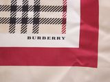 a burberry scarf on a bed with a red and white blanket