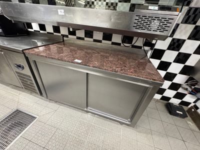 une cuisine avec des placards en inox et un plan de travail en marbre