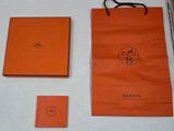 un sac en papier orange et un livre posés sur une table