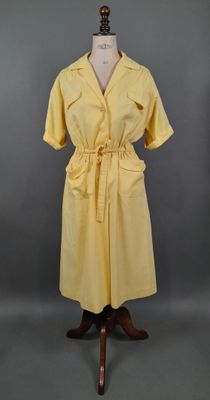 une robe jaune sur un mannequin, sur fond gris