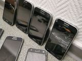 several cell phones are lined up on the floor next to a bed
