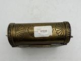 an old brass cigarette case with a label on it