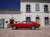 a red car parked in front of a large building