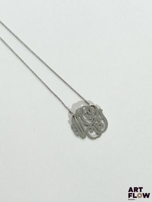 a close up of a necklace on a white surface with a white background