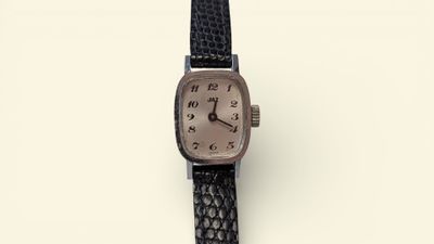 an image of a wrist watch with a brown face and black leather strap