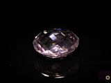 a close up of a pink diamond on a black surface