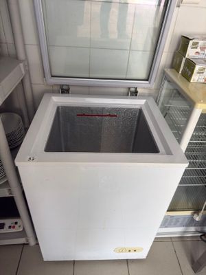 a freezer that is sitting in the corner of a kitchen