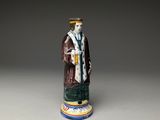 an image of a figurine of a man with a hat and robe