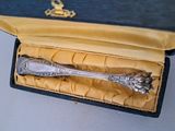 a silver spoon in a black box with a gold lining