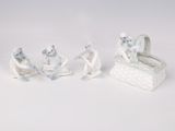three figurines of a baby in a basket and a baby in a crib
