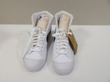 white sneakers with black soles and white laces on a white surface