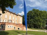a blue flag in front of a building on the grass