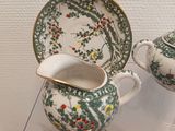 two cups and a saucer sitting on a glass table