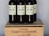 four bottles of wine are in a wooden box on a table