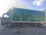 a green truck that is parked in front of a building