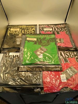 beaucoup de t-shirts dans une valise posée par terre