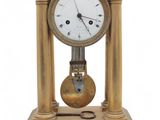 a gold clock sitting on top of a wooden table