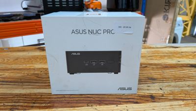 Le carton de l'ASUS NUC Pro est posé sur une table en bois
