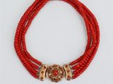un collier de perles rouges, composé de perles dorées et rouges