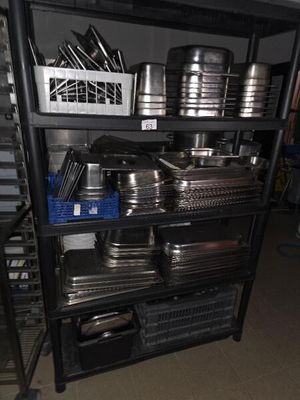 many pans and pans on a shelf in the kitchen