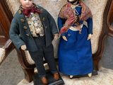 two dolls sitting next to each other on a chair