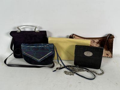 three purses and a handbag are sitting on a table