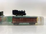 two toy trains in a clear box on a white surface