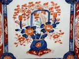 an orange and blue plate with a picture of a woman holding a basket of flowers