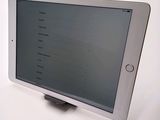 tablet computer sitting on top of a white table with a mouse on top of it