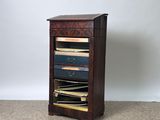 a tall wooden cabinet with a drawer full of books
