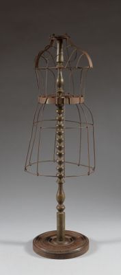 a metal mannequin on a stand with a wooden base