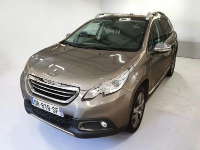 La voiture argentée est garée dans une pièce blanche au sol blanc.