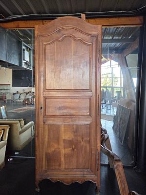 a tall wooden cabinet in a room with a lot of furniture