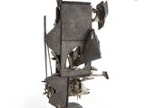a metal sculpture of a ship on a white surface