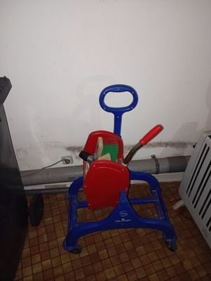 une petite voiture jouet rouge et bleue sur laquelle sont posés des outils