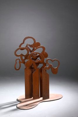 une sculpture représentant un arbre, réalisée en métal et posée sur un morceau de bois