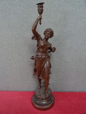 statue en bronze représentant une femme tenant une torche à la main