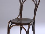 une chaise en bois avec un dossier courbé et une assise en cuir